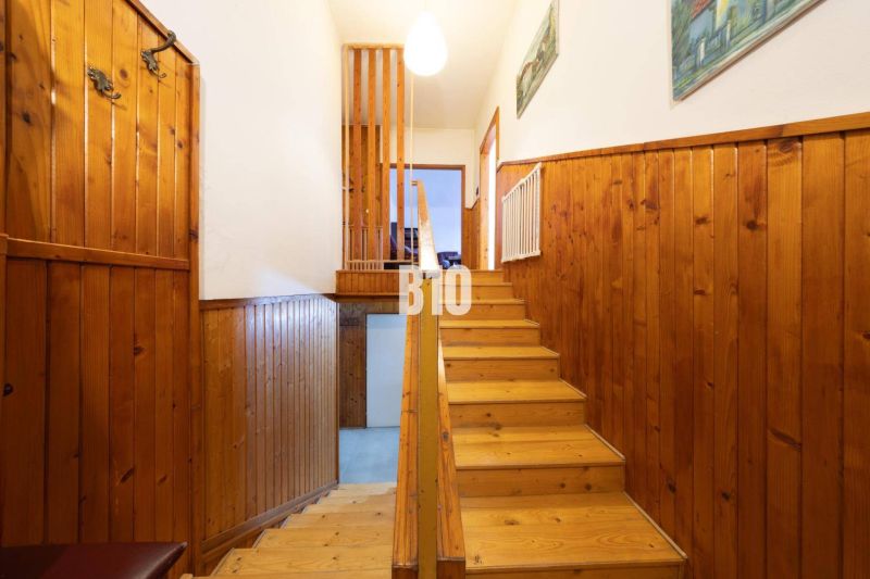 Holztreppe und Wandverkleidung in einem Einfamilienhaus mit einem Boden in Holzoptik.