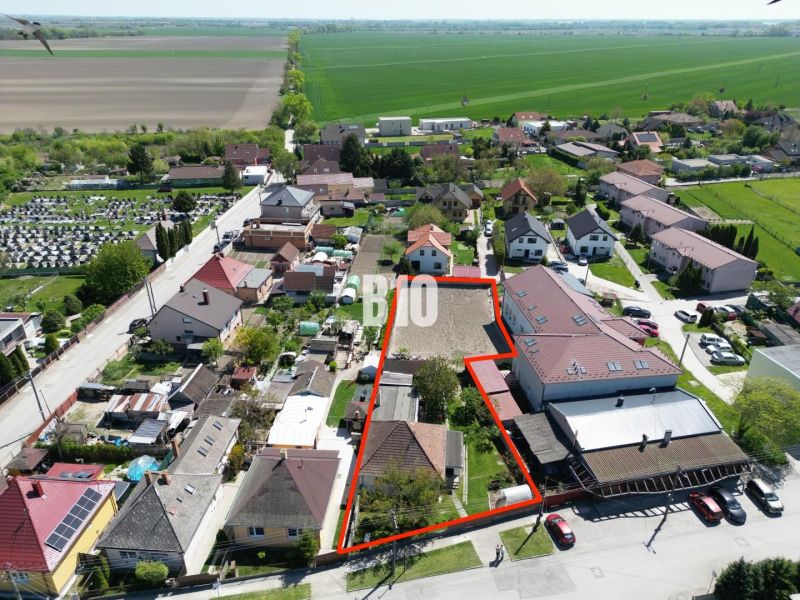 Luftaufnahme von Einfamilienhäusern in Kalinkovo, mit einem Grundstück, das mit einer roten Linie markiert ist.