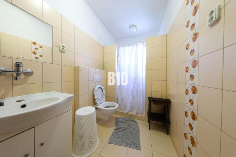 Badezimmer in einem Einfamilienhaus mit Fliesen und Toilette.