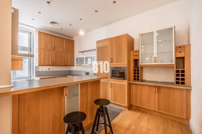 Küche in einer 5-Zimmer-Wohnung mit Holzboden und Holzschränken.