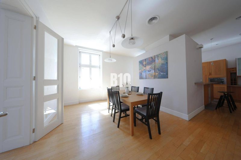 Esszimmer in einer Wohnung mit 5 oder mehr Zimmern mit Holzboden und einem Tisch für sechs Personen.