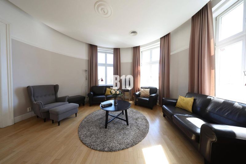 Wohnzimmer mit Ledersofas und Holzboden in einer Wohnung mit 5 oder mehr Zimmern.