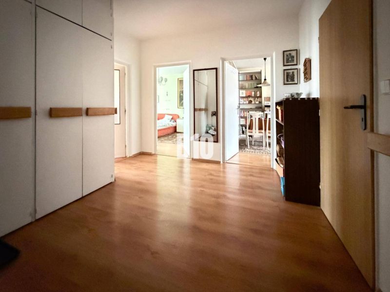 Der Flur einer 3-Zimmer-Wohnung mit Holzboden und Einbauschränken.