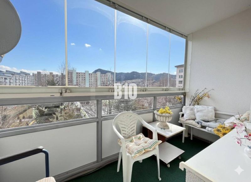 Ein möblierter Balkon in einer 3-Zimmer-Wohnung mit Blick auf Ružomberok und Plattenbauten.