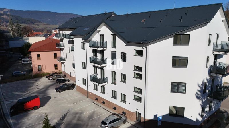 Ein Gebäude mit weißer Fassade und einem Parkplatz in der Matúškova-Straße in Dolný Kubín, Büros.