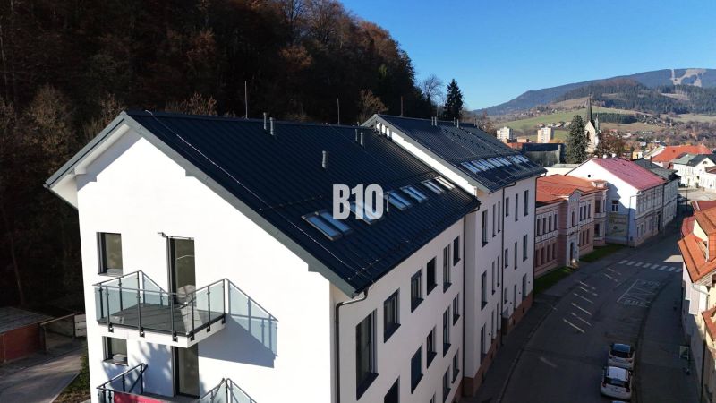 Bürogebäude in der Matúškova-Straße in Dolný Kubín, umgeben von Berglandschaft.