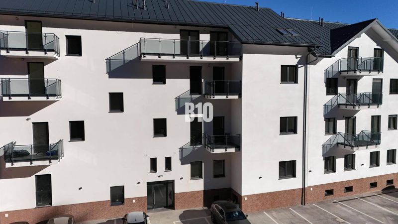 Die Fassade eines Wohnhauses in Dolný Kubín mit Parkplatz und Balkonen, ideal für eine 2-Zimmer-Wohnung.