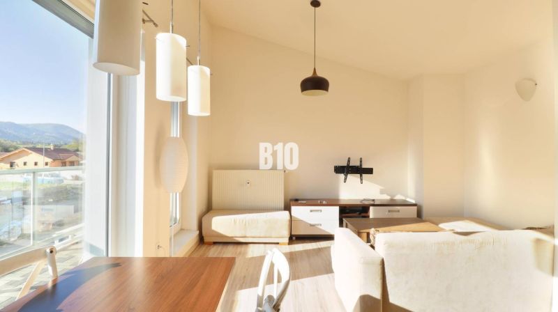 Innenraum einer 2-Zimmer-Wohnung mit Holzboden, hellen Wänden und großen Fenstern.