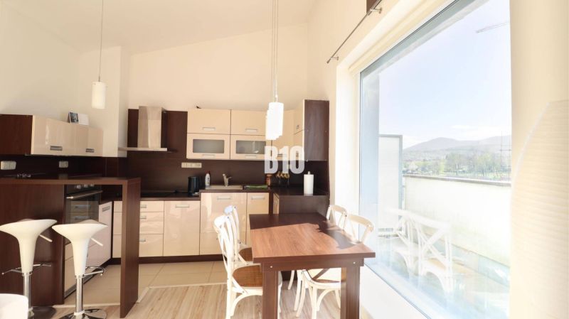 Küche in einer 2-Zimmer-Wohnung mit großem Fenster und Holzboden.