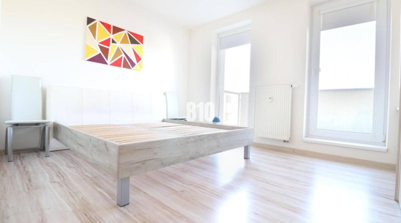 Helles Zimmer mit einem Bett auf dem Boden mit Holzdekor in einer 2-Zimmer-Wohnung.