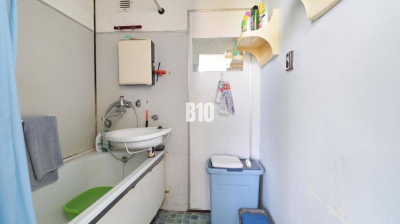 Badezimmer mit Duschvorhang und Waschbecken in einer 3-Zimmer-Wohnung.