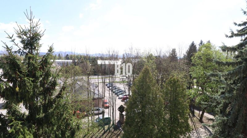 Blick aus einer 3-Zimmer-Wohnung in Martin, mit Aussicht auf Grünflächen und einen Parkplatz.