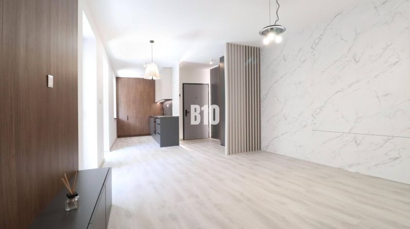 Innenraum einer 2-Zimmer-Wohnung mit Holzboden und Marmorverkleidung.