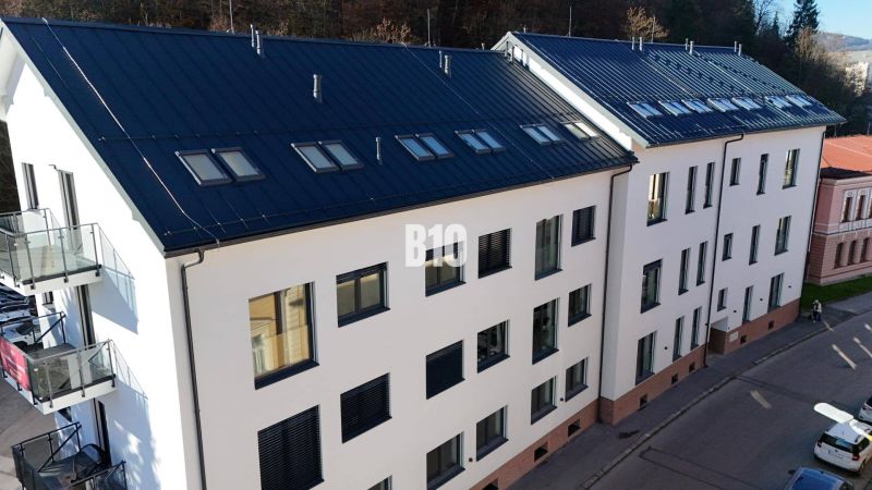 Ein Wohnhaus in Dolný Kubín mit modernen Fenstern und Balkonen, ideal für eine 2-Zimmer-Wohnung.
