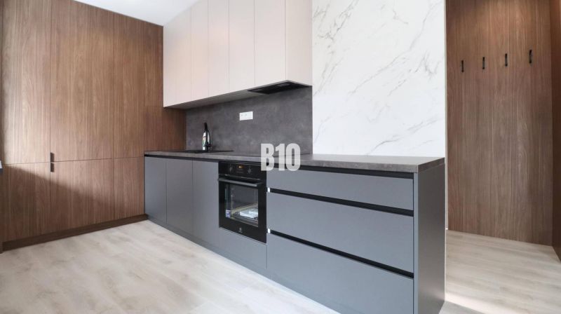 Küche in einer 2-Zimmer-Wohnung mit Holzboden und modernen Schränken.