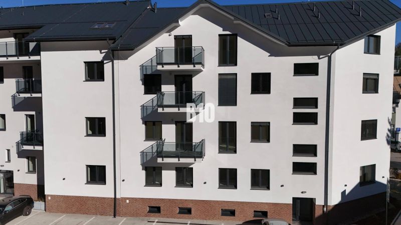 Ein Wohnhaus in Dolný Kubín mit Parkplätzen und Balkonen.