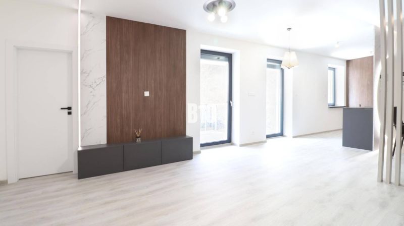Helles Interieur einer 2-Zimmer-Wohnung mit Holzboden und großen Fenstern.