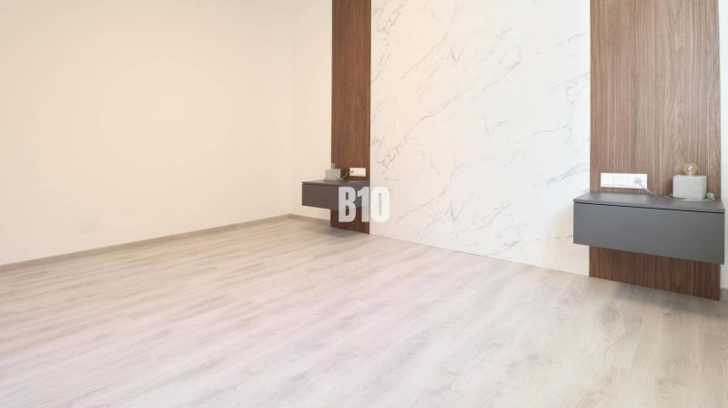 Innenraum einer 2-Zimmer-Wohnung mit Holzboden und dekorativer Wand.