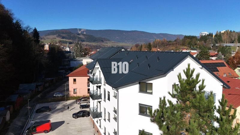 Neubau eines Wohnhauses in Dolný Kubín, mit Blick auf die Berge und einem Parkplatz.