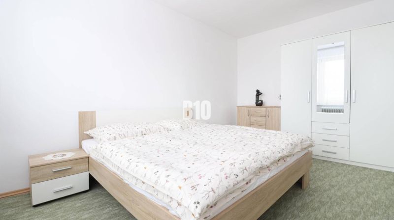 Schlafzimmer mit Kleiderschrank und Doppelbett in einer 3-Zimmer-Wohnung. Der Kleiderschrank hat einen Spiegel.