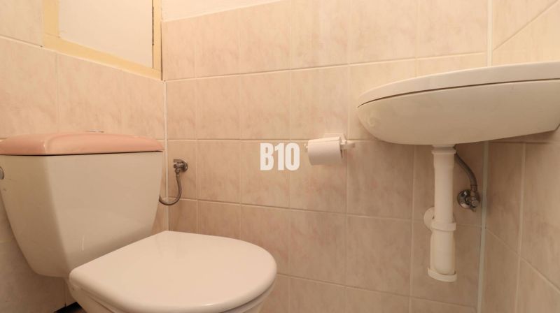 Toilette und Waschbecken im Badezimmer in einer 3-Zimmer-Wohnung mit Fliesen.