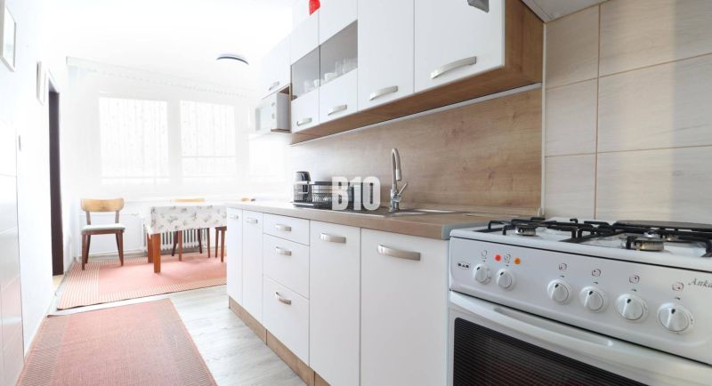 Küche in einer 3-Zimmer-Wohnung mit Gasherd und Boden in Holzoptik.