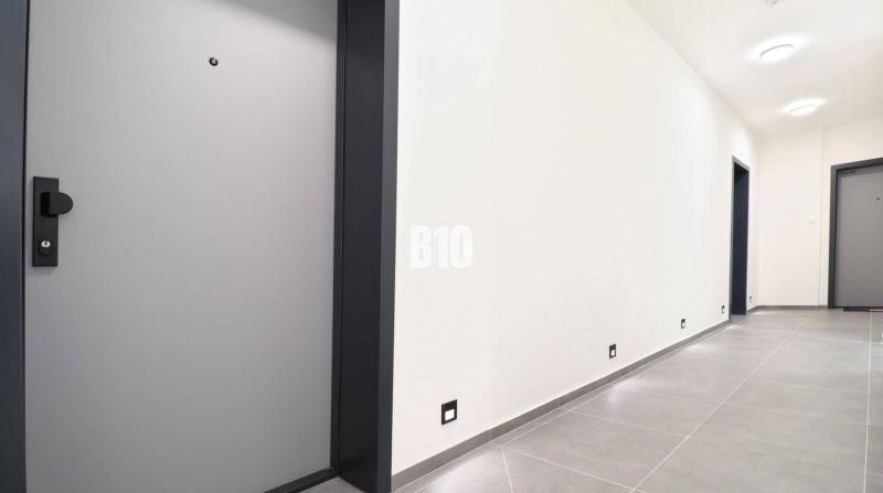 Der Flur in der 2-Zimmer-Wohnung mit Fliesen in einem hellen Farbton und Türen.