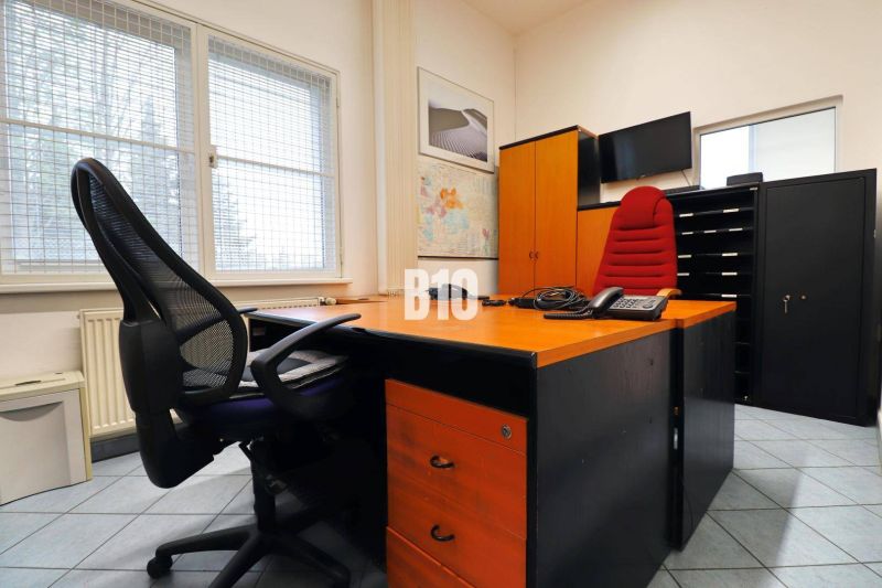 Kanzlei in Produktionsräumen mit Stühlen, Tisch und einer Karte an der Wand.