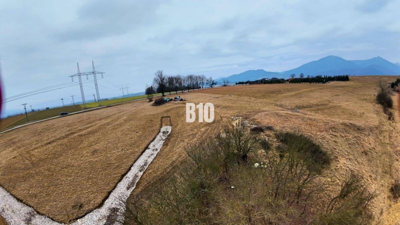 Hügelige Landschaft in Laskári, geeignet für Wohnbaugrundstücke, mit Stromleitungen im Hintergrund.