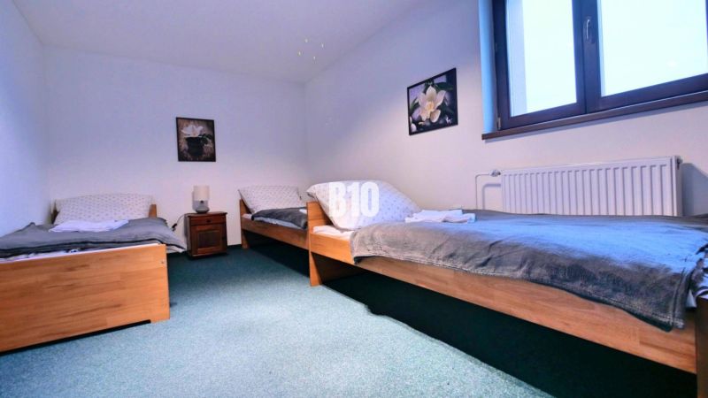 Schlafzimmer mit drei Betten und dekorierten Elementen in einer 3-Zimmer-Wohnung.