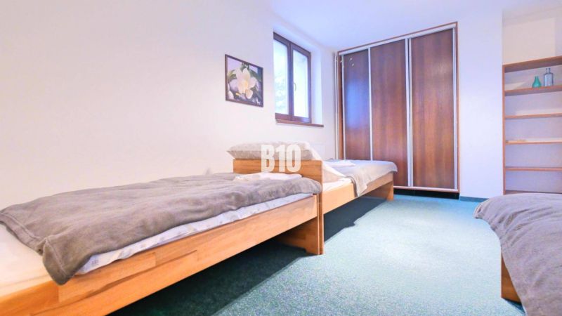 Schlafzimmer in einer 3-Zimmer-Wohnung mit zwei Betten und einem Einbauschrank.