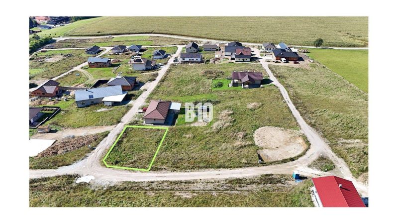 Ein Baugrundstück in Necpaly, eingebettet zwischen Häusern, bereit für den Bau.