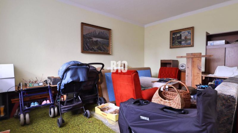 Innenraum mit Kinderwagen, Möbeln und Bildern in einem Einfamilienhaus.