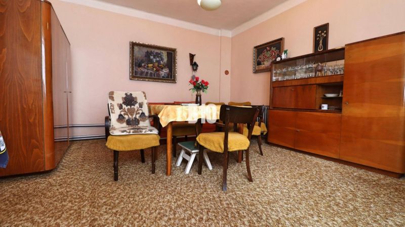 Esszimmer in einem Einfamilienhaus mit Holzmöbeln, gelbe Sessel, Teppiche.