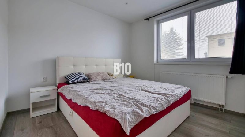 Schlafzimmer in einer 3-Zimmer-Wohnung mit einem Doppelbett und einem Boden mit Holzdekor.