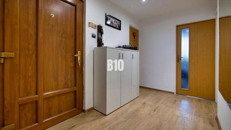 Eingangsbereich in einer 3-Zimmer-Wohnung mit Holzboden und Holztüren.