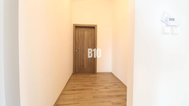 Flur mit Türen und einem Boden mit Holzdekor im Einfamilienhaus.