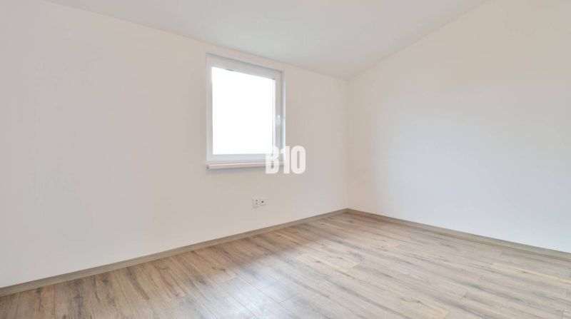 Ein leerer Raum mit Holzboden in einem Einfamilienhaus.