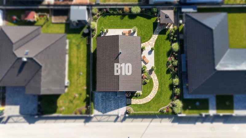 Luftaufnahme eines Einfamilienhauses in Diaková mit gepflegtem Garten und Gehweg.