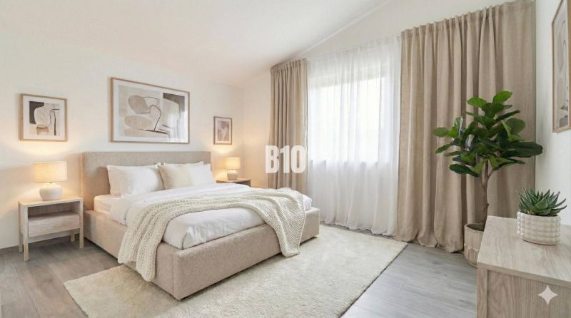 Helles Schlafzimmer mit großem Bett, Vorhängen und Pflanzen in einem Einfamilienhaus.