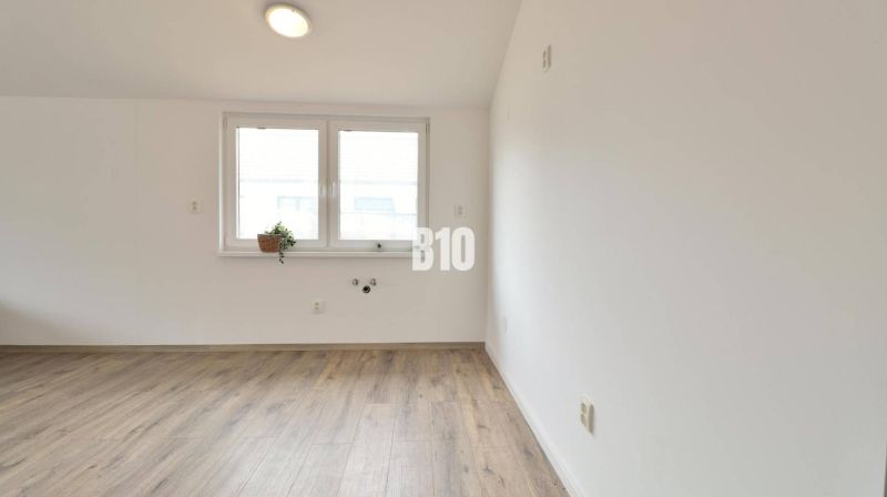 Ein leerer Raum in einem Einfamilienhaus mit Holzboden und einem Fenster.