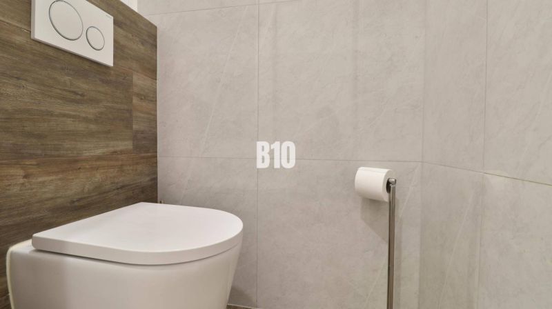 Badezimmer mit Toilette und Holzelementen in einer 3-Zimmer-Wohnung.