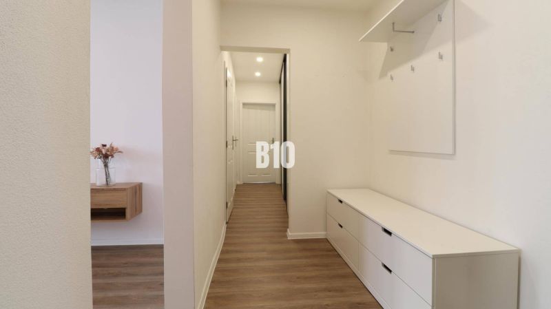 Flur einer 3-Zimmer-Wohnung mit Holzboden und Stauraum.
