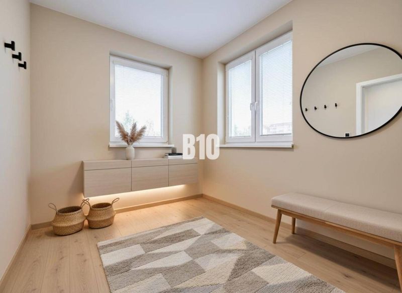 Innenraum eines Einfamilienhauses mit einer Bank, einem runden Spiegel und einem Boden mit Holzdekor.