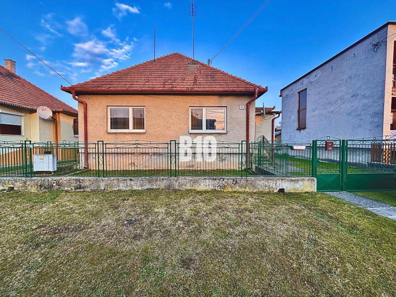Ein Einfamilienhaus in Sľažany mit Vorgarten und Schrägdach zwischen benachbarten Gebäuden.