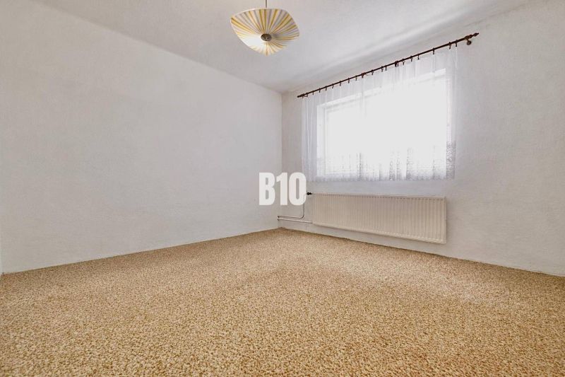 Geräumiges Zimmer mit Teppich und Vorhängen in einem Einfamilienhaus.