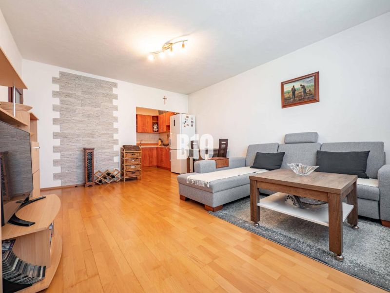 Wohnzimmer in einer Zweizimmerwohnung mit Holzboden und gemütlicher Sitzecke.