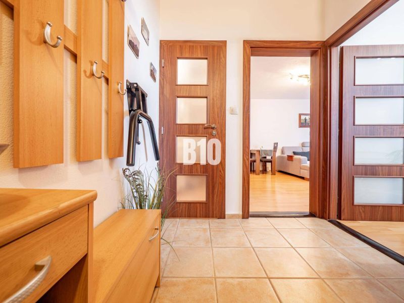 Eingangsbereich in einer 2-Zimmer-Wohnung mit Holzboden und Garderobe.