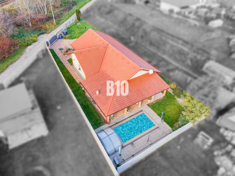 Luftaufnahme eines Einfamilienhauses in Nitra mit zwei Dächern und einem Pool.