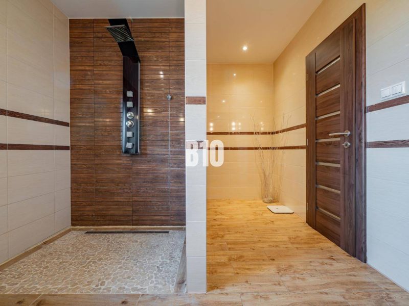 Badezimmer in einem Einfamilienhaus mit Holzboden und Duschkabine.